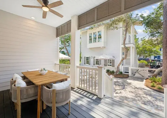 Dinner alfresco, every night — a shaded porch table just off the kitchen, with the patio and grill waiting below.