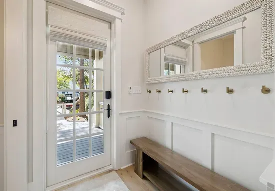 The hardest-working spot in a beach house — a mudroom drop zone for wet towels, sandy shoes, and beach bags, right by the back door.