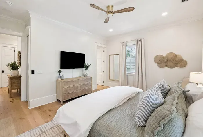 Sink into layered, luxe bedding at the end of a beach day. A mounted smart TV makes this room a cozy escape of its own.
