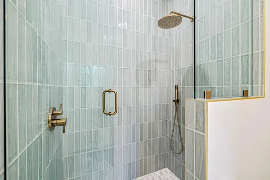 Rinse off the salt and sand under a rainfall showerhead — hand-laid tile and a handheld sprayer make it spa-easy.