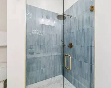 A beautifully tiled walk-in shower, complete with a rainfall head and hand-held rinser.