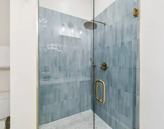 A beautifully tiled walk-in shower, complete with a rainfall head and hand-held rinser.