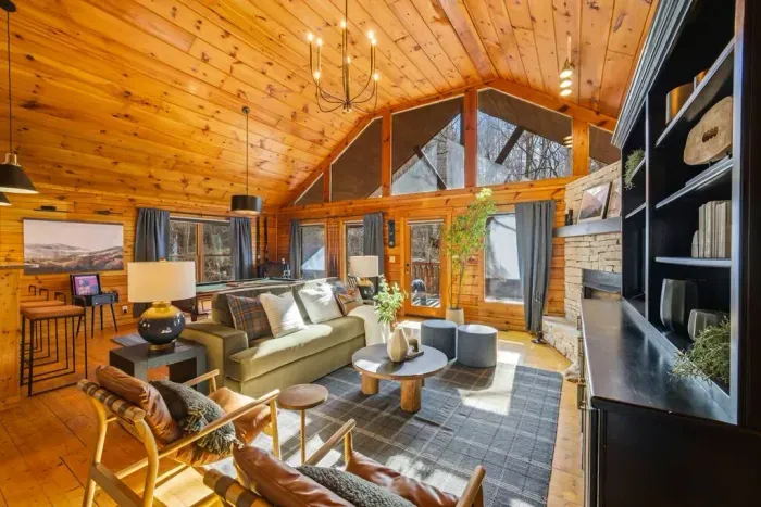 Bright and spacious main-level living room with a sleeper sofa, vinyl record player, and pool table—perfect for relaxing or entertaining.