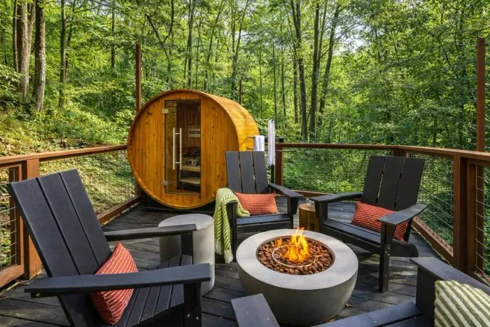 Lower-level deck with a barrel sauna and fire pit, perfect for relaxing outdoors.