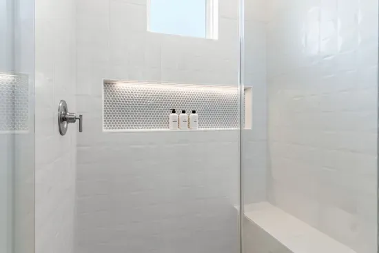Thoughtfully designed for every guest, each bathroom features spacious curbless showers with built-in benches, blending accessibility with modern comfort and style.