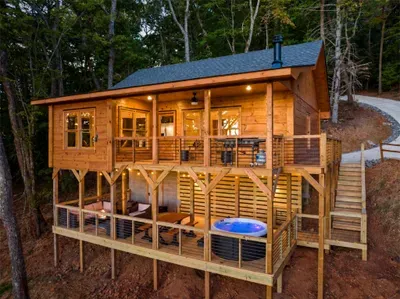 Secluded mountain cabin on top of ridgeline with decks, cozy lounge space, and private hot tub. Handmade farmhouse table.
