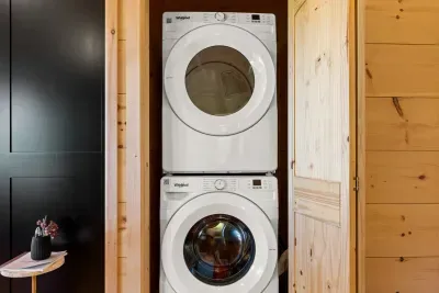 Convenient in-unit washer/dryer tucked into a cozy wood-paneled space