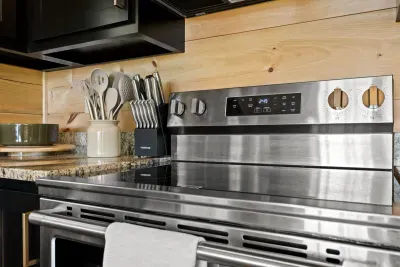Modern kitchen with stainless range, granite counters, and rustic wood accents