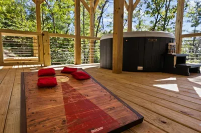 Covered forest deck with private hot tub and cornhole fun