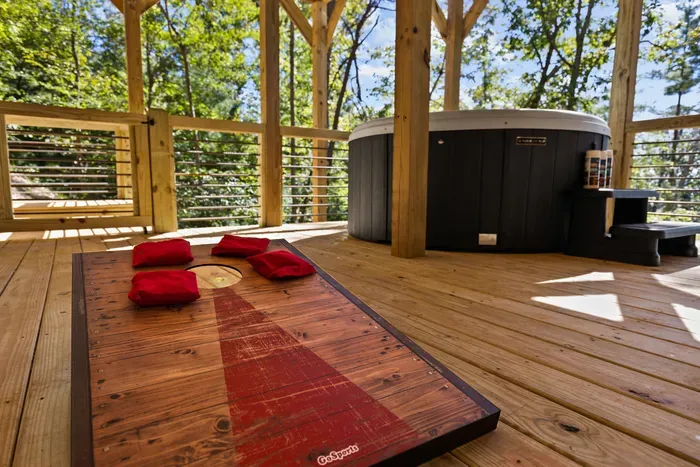 Covered forest deck with private hot tub and cornhole fun