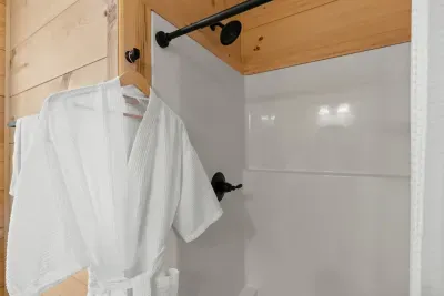 Spa-like shower with cozy cabin details and luxe robe. Hall bath
