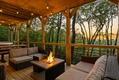 Covered forest-view deck with cozy fire table and sunset ambiance