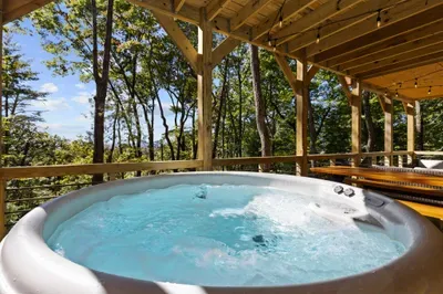 Covered forest-view hot tub with cozy deck seating