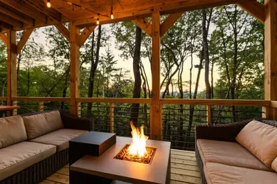 Cozy covered deck with fire table, forest views, and sunset ambiance