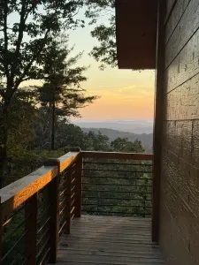 Covered deck with sunset mountain views and a peaceful forest setting
