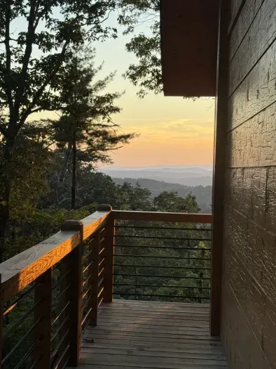 Covered deck with sunset mountain views and a peaceful forest setting