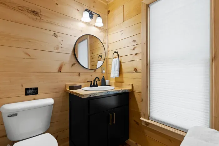 Cozy cabin-style bath with rustic wood accents and modern black finishes