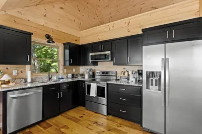 Modern cabin kitchen with granite counters and stainless appliances