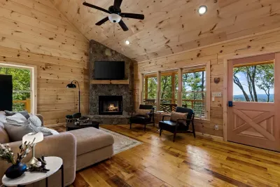 Cozy cabin living room with stone fireplace and scenic mountain views