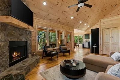 Cozy cabin great room with stone fireplace and serene mountain views