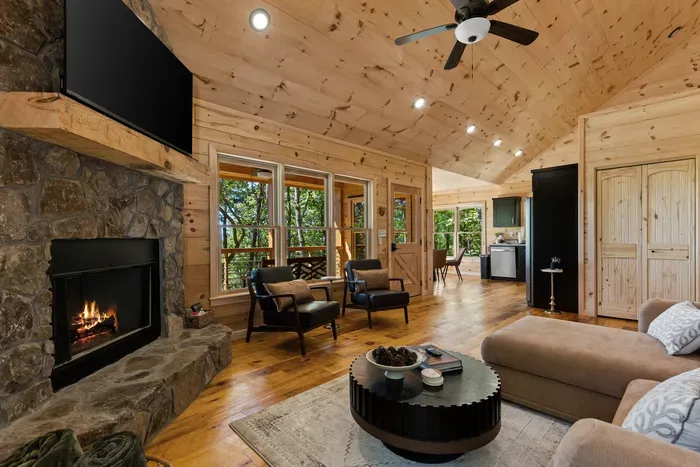 Cozy cabin great room with stone fireplace and serene mountain views