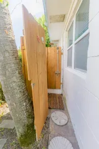 Outdoor Shower Oasis: Refresh in this charming wooden shower set among lush greenery!