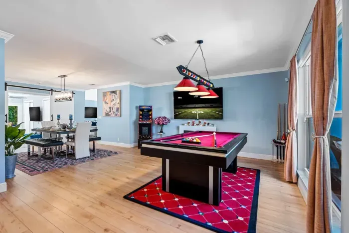 The pool table room flows seamlessly into the dining room, kitchen, & family room.