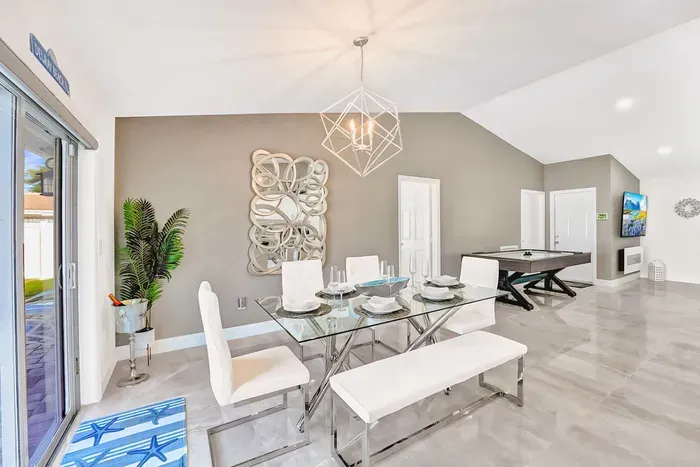 With the continuous flow of modern and sleek decoration into the dining area with wall art, stylish light and a touch of nature in the corner with the green plant.