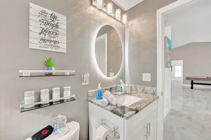 The stunning modern accent wallpaper combined with the tiling creates a luxurious feel whilst the sleek vanity area provides the perfect place to check yourself out in the LED lit mirror.