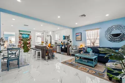 The open-floor plan living area conveniently combines the living room with the kitchen and the dining area.