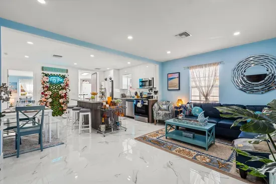 The open-floor plan living area conveniently combines the living room with the kitchen and the dining area.