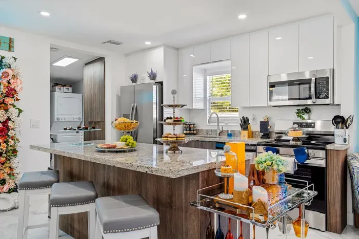 Offer a piece of advice to the family chef while sipping refreshing drinks at the kitchen island.