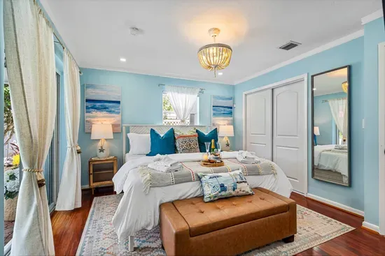Resort-like comforts wait for you in all four bedrooms.  Pictured here is the primary with pool view and access through the sliding glass doors.