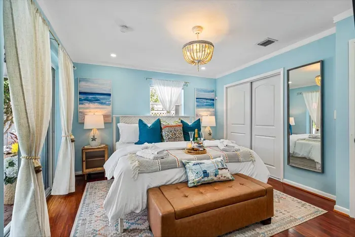 Resort-like comforts wait for you in all four bedrooms.  Pictured here is the primary with pool view and access through the sliding glass doors.