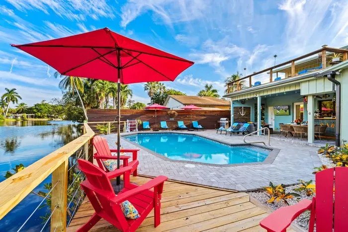 This waterfront yard is designed for all-day enjoyment, with an easy flow between the pool, lanai, deck, and canal-front relaxation areas.