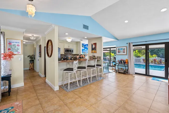 The airy living room flows into the kitchen and dining area, giving you a spacious central hub to relax, chat, and plan your next beach adventure.
