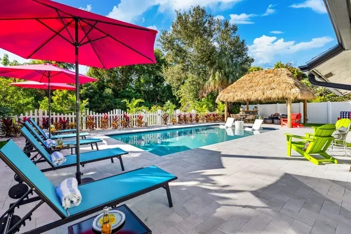 Lounge by the pool on comfortable seating, sipping your favorite drink while watching the water sparkle and the palm trees sway.