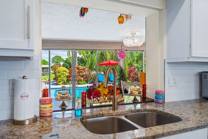 Enjoy direct views of the private pool and waterfront backyard from the fully equipped kitchen.