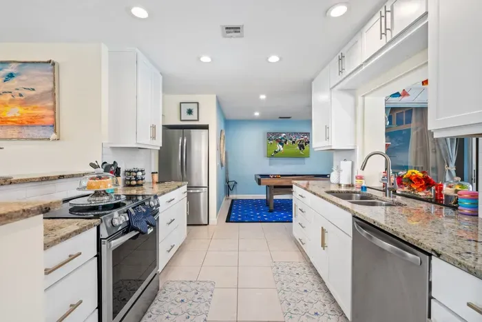 Cook with ease in the full kitchen featuring modern appliances, spacious quartz countertops, and all the cookware you need for family meals between pool sessions and beach trips.