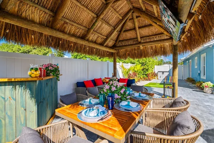 Enjoy tropical vibes at the Tiki hut with seating, a bar, and a 65" smart TV, creating a fun and relaxing atmosphere.