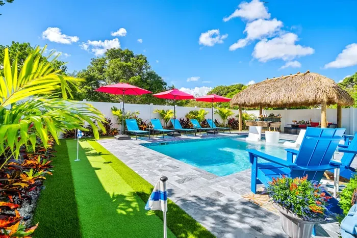 You'll be surrounded by lush, leafy, and colorful plants, enhancing the tropical vibes of the fully fenced backyard.