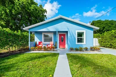 Follow the charming concrete pathway to the red doors!