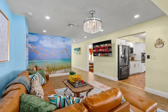 Relax in the spacious and colorful open-concept living area, featuring a plush L-shaped leather sofa perfect for movie nights or family gatherings.