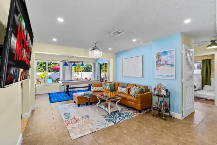 Natural light floods the living space through large windows and backyard doors, creating a bright and inviting atmosphere.