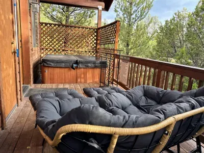 Private forest-view deck with hot tub and cozy outdoor lounge seating