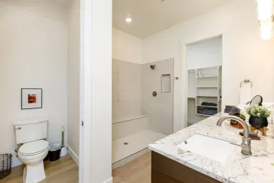 Primary bathroom features separate toilet room and double-headed shower. *Shower glass added after photography.