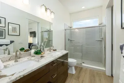 Second bathroom attached to queen bedroom features a double vanity and a double-headed shower. 