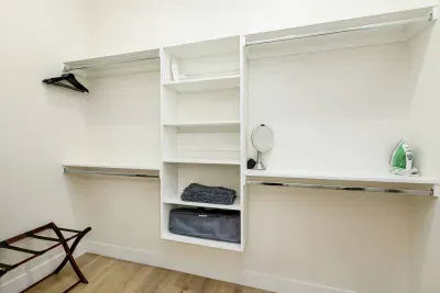 Large primary closet includes plenty of storage, an iron, and a pack n play for our tiny guests. 