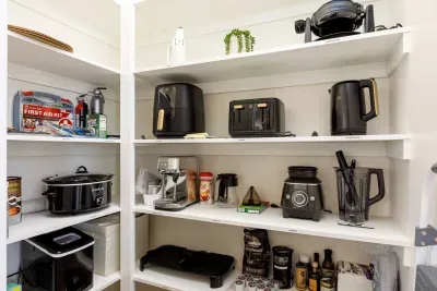 Pantry is fully stocked with small appliances. 