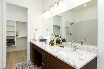 Primary ensuite bathroom with a double vanity and large closet. 